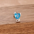 Détail macro des boucles d'oreilles cœur en pierre bleue avec accents de cornes de diable - Style Coeur Petit Diable avec Pierre Bleue (Y26509-Argent Bleu)