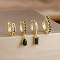 Macro detail of four gold earrings set with black zircons on a metallic display stand - 4-Piece Set / Black
