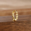 Close-up of a gold huggie hoop earring with clear cubic zirconia on wood - Style 10 Diamond Row (10-Gold-White-1pc)