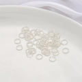 Gros plan d'anneaux de jonction torsadés argentés pour bijoux DIY sur plateau - 6mm (20 Pièces) / Plaqué Argent Épais