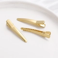 Dettaglio di fermagli per capelli placcati oro 14K con bordi seghettati su piatto ceramico - Stile Appuntito Medio