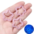 Detailed view of pink glitter star charms with blue glowing effect in the dark - Light Purple