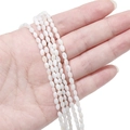 Detailansicht der 3mm cremeweißen Süßwassermuschelperlen in der Hand für Schmuckherstellung - 3x5mm (ca. 80 Stück/Packung) / Weiß