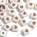 Gros plan sur des perles cubiques holographiques avec cœur pour la création de bijoux - Cube Blanc Cœur Café