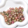 Primer plano de cuentas de vidrio veteadas en rosa y verde con purpurina dorada para DIY - 10mm / Color 7