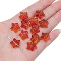 Macro shot of orange star-shaped glass beads showing hole structure for DIY jewelry - 10 Pieces/Pack (15x14mm) / Red-Yellow Gradient