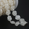 Macro shot of cream white pearl rose bead chain on a spool for DIY bridal dress trim - Beige Rose Connected Bead Chain (16mm, 10m/Roll)