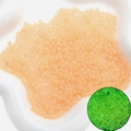 Macro view of 2-3mm glowing glass beads showing natural pink tint and bright green luminescence - No Hole Diameter 2-2.5mm 30g/Pack Approx 2100pcs / Orange