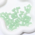 Light green glass bamboo tube beads for DIY jewelry making in a white tray - Aventurine Jade Green
