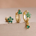 Detail eines dreiteiligen goldenen Ohrring-Sets mit grünen Edelsteinen und Sternanhängern - Gold Grüner Stern Edelstein Stil (Y27280)