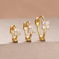 Vue macro de trois boucles d'oreilles fleurs dorées serties de zircons blancs - Or Blanc (Y27268)