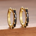 Detailed close-up of golden huggie hoop earrings with black rectangular inlay on a wooden stand - Gold Black