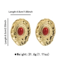 Detailed view of oversized vintage gold earrings with red resin stones and rhinestones - Red