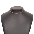 Collier tennis en cristal rose avec base dorée présenté sur un support à bijoux - Rose