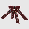 Macro shot of burgundy velvet bow hair clip with colorful rhinestones and white pearls - Burgundy