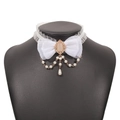 Detail of white lace bow choker with faux pearl charms and pink gemstone on a black bust - White