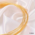 Primer plano de alambre para joyas de 0,4mm bañado en oro 18K sobre seda blanca - 0.4mm de Diámetro (1 Metro)