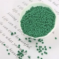 Dettaglio macro di perline di vetro verde scuro opaco per bigiotteria fai-da-te in ciotola - 20g Per Confezione Circa 700 Pezzi / 3mm Verde Scuro