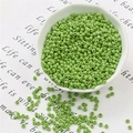 Dettaglio di perline verde matcha opaco per gioielli fai-da-te in una ciotola di ceramica - 20g Per Confezione Circa 700 Pezzi / 3mm Verde Oliva