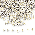 Macro shot of 5mm white acrylic cube beads with gold letters and threading holes for DIY - White Base Gold Font