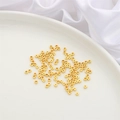 Vista macro di perline distanziatrici triangolari placcate oro 14K su fondo bianco - Foro Centrale Triangolo 2.5x1.5mm (Apertura 0.8mm) 10 Pezzi/Confezione / Placcato Oro 14K