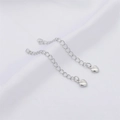 Cadenas de extensión ajustables plateadas con colgantes de corazón sobre tela blanca - Estilo Corazón Liso Platinado