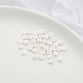 Flat round silver spacer beads on a white ceramic tray for DIY jewelry making - 10 Pieces (5x2mm) / Silver - Flat Bead