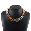 Vue détaillée d'un collier de cristaux colorés avec monture en métal doré griffé - Collier imposant multicolore avec pierres mélangées / Coloré
