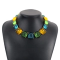 Vue macro d'un collier ras de cou en résine bohème avec des pierres colorées serties de griffes - Collier imposant gelée orange jaune vert bleu (N11320)