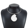 Gros plan d'un collier ras du cou argenté avec pendentif en forme de coquillage texturé - Collier Rigide Métal Pendentif Conque Argenté (N11399)