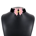 Close-up of black velvet choker featuring symmetrical pink flower charms and golden details - Pink