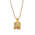 Macro view of iced out bubble letter H pendant with orange zircon drip and rope chain - Letter H