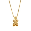 Close-up of hip hop gold rope chain with iced out X pendant and orange gemstone detail - Letter X