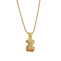 Macro detail of iced-out Z letter pendant with orange lava drip on golden rope chain - Letter Z