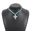 Detail of turquoise gravel necklace with a vintage silver textured cross on a black bust - Turquoise