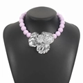 Statement necklace with purple beads and oversized silver flower pendant on a black bust - Purple Silver