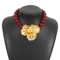 Detail of deep red beaded necklace featuring a large vintage style golden flower pendant - Rose Gold Red