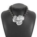 Detailed view of grey beaded necklace with large silver metal flower pendant on black bust - Grey Silver
