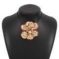 Primer plano de collar con colgante de flor dorada y bordes de esmalte rojo vivo - Collar Oro Rojo