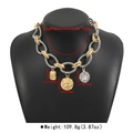 Detail of chunky twisted chain necklace with vintage coin pendants and gold-silver finish - Antique Silver + Gold
