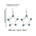Detail view of retro bohemian star earrings with turquoise inlays and size measurements - E13414