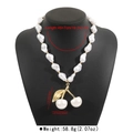 Detailed view of Baroque pearl necklace with cherry pendant on a black bust display - Necklace (N12618) / Gold