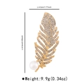 Makro-Detail der goldenen Federbrosche mit Kristallen und Perle zeigt 6,5 cm Höhe - Feder