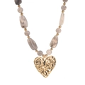 Detalle de un colgante de corazón de oro martillado en un collar de cuentas marmoladas - Estilo Corazón Martillado / Gris