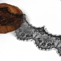Macro view of black eyelash lace trim with floral patterns and delicate mesh texture - Black