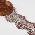 Nahaufnahme von dunkelbrauner Wimpernspitze mit Stickerei auf einem rustikalen Holzblock - Kaffeebraun