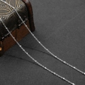 Macro detail of a silver O-chain with small cylindrical beads for DIY jewelry making - 1 Meter/Pack / Silver O-Link Chain with 2mm Beads
