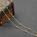 Detailed view of elegant gold-plated beaded chain draped on a vintage jewelry box - 1 Meter/Pack / Gold O-Link Chain with 4mm Beads