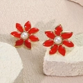 Detalle macro de pendientes de flor roja con borde dorado y perla blanca - Rojo