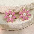 Detalle de pendientes de flores de esmalte rosa con perla blanca y bordes dorados - Rosa